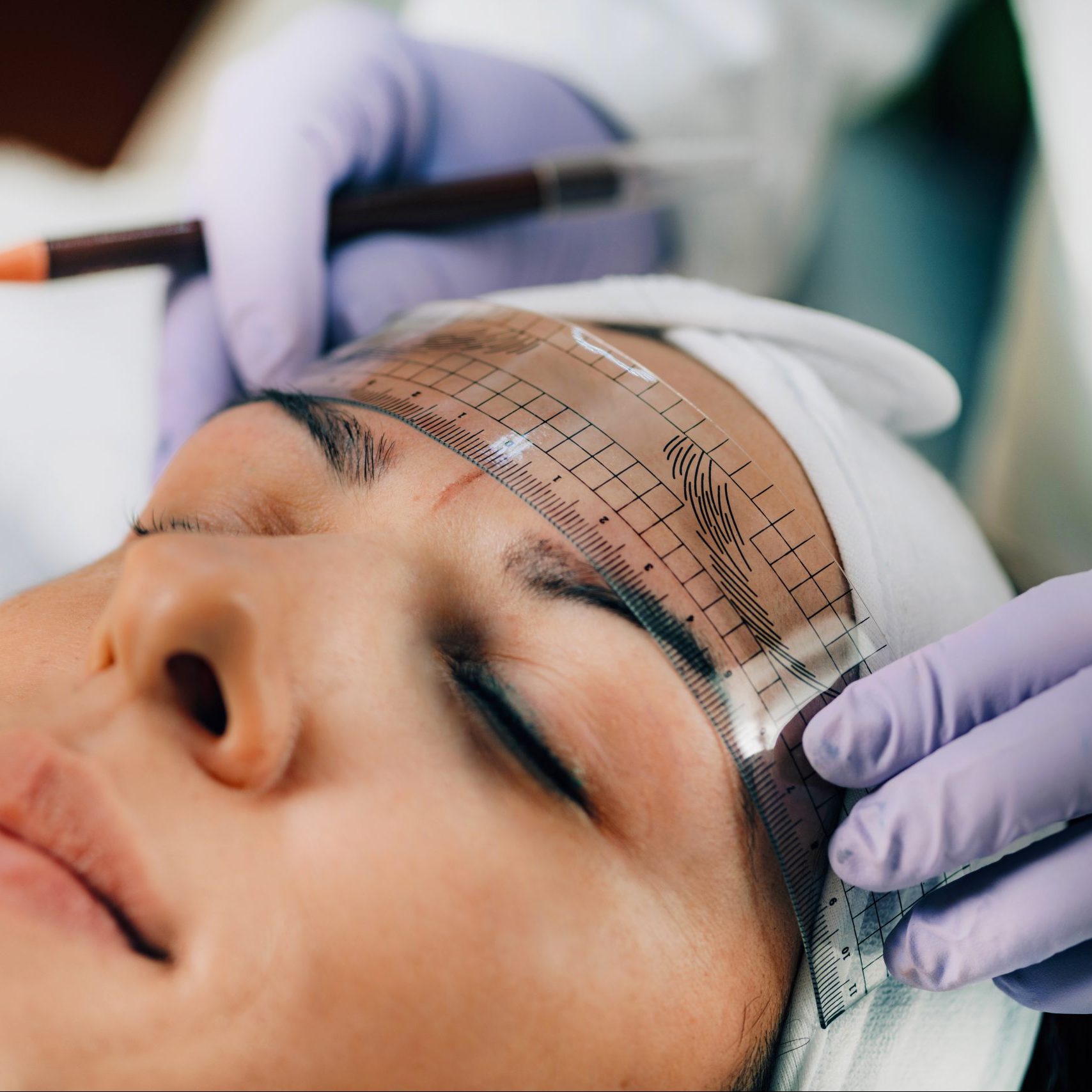 Beautician Addressing the Shape of the Brows Before Microblading.  Semi-Permanent Makeup